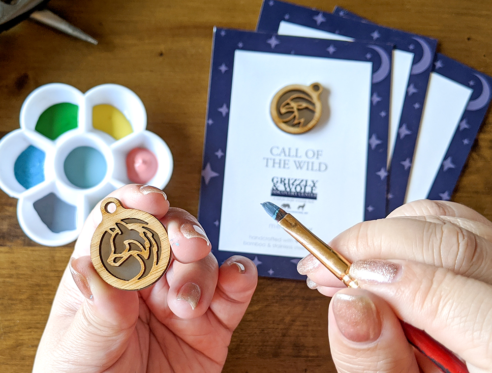 Painting a wolf necklace with a eagle necklace in the background