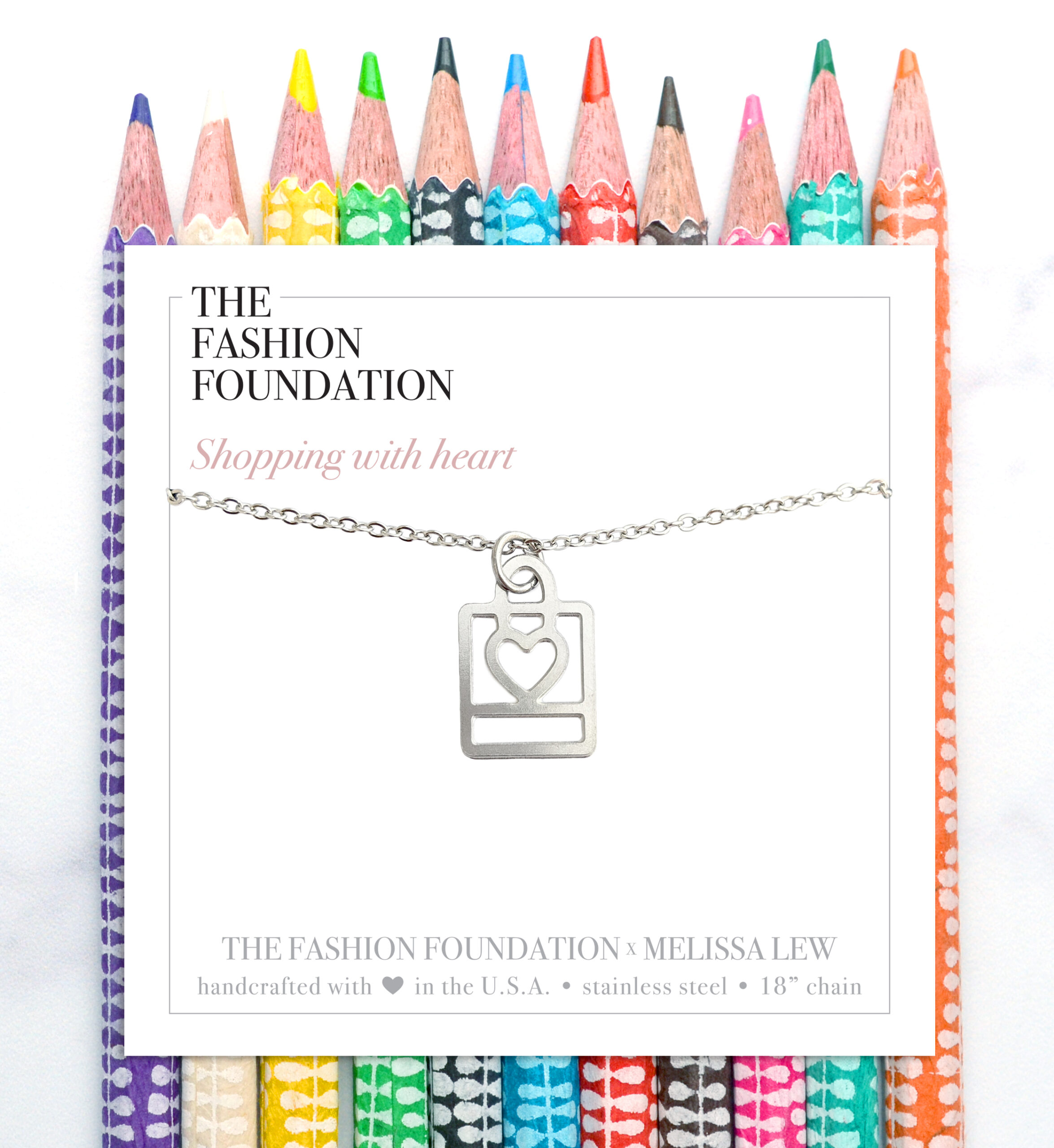 Shopping bag and heart necklace on a background of colored pencils